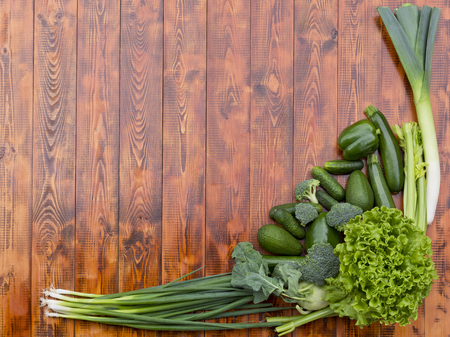 Green vegetables on wooden background. Free space for your text.の写真素材