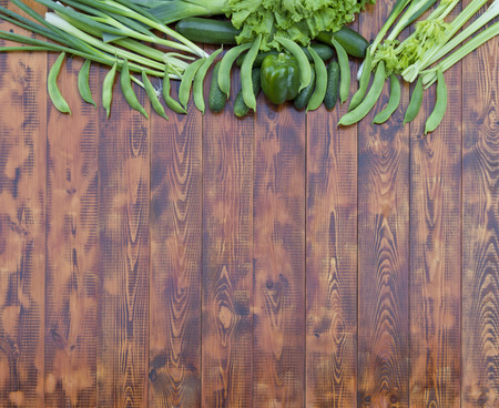 Green vegetables on wooden background. Free space for your text.の写真素材