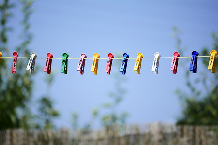 Rope with plastic cloth clips against the blue sky.の写真素材