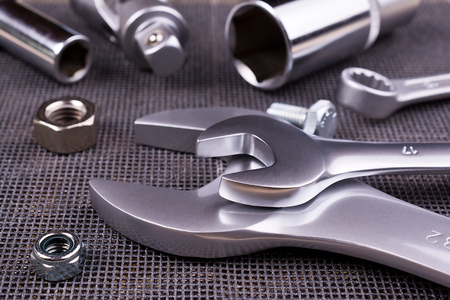 Set of  wrenches, nuts and bolts on a metal background.の写真素材