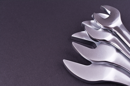 Spanners of various sizes, on dark abstract background.の写真素材