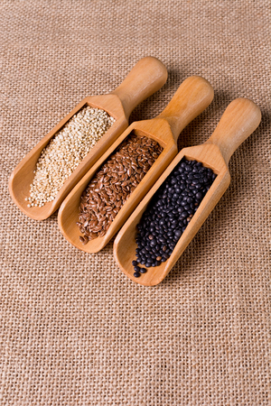 Lentils, flax and quinoa seeds in wooden spoon.の写真素材