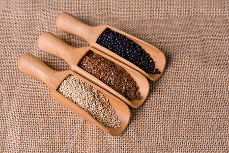 Lentils, flax and quinoa seeds in wooden spoon.の写真素材