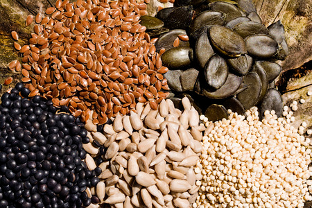 Pumpkin seeds, sunflower, chickpeas, quinoa and flax seeds on a wooden background.の写真素材