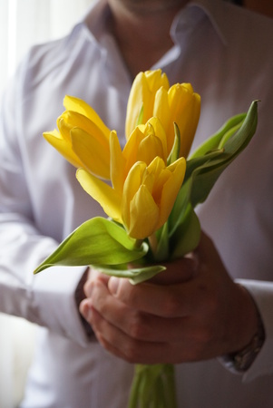 man giving a bouquet of yellow flowersの写真素材