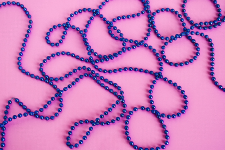 Ornament of blue beads on a pink background.の写真素材