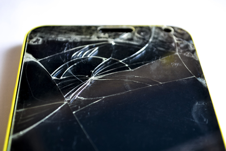 Modern mobile phone with broken screen on light backgroundの写真素材