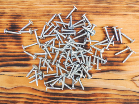 Screw with washer on metal on a wooden background.の写真素材