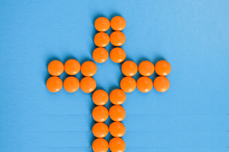 A clinic icon from orange pills on a blue background.