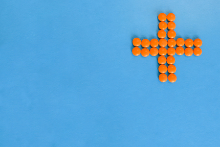 A clinic icon from orange pills on a blue background.の写真素材
