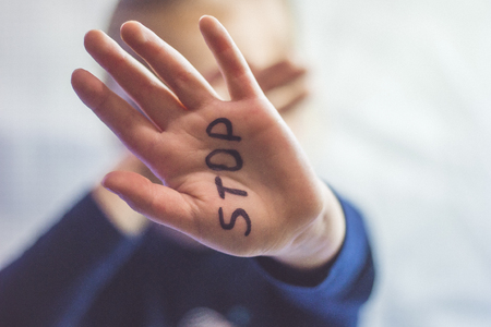 Little frightened girl shows the word Stop written on the arm. Children are subjected to violence and publishing in the home and school concept and the rights of children.の写真素材