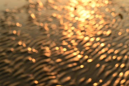 blur bokeh light from sunset on beach backgroundの写真素材