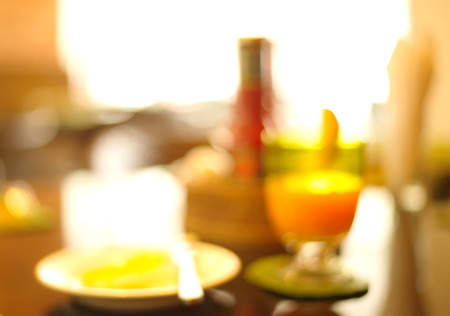 blur breakfast with orange juice on table backgroundの写真素材