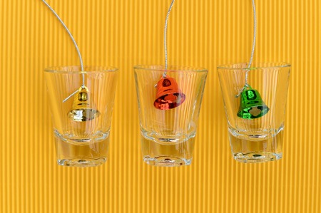 christmas bells in glass on yellow background