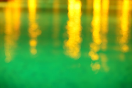 blur  gold light refection in blue water at swiming poolの写真素材