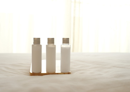 three plastic bottle with white cream liquid on bedの写真素材