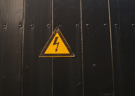high voltage sign on black painted woodの写真素材