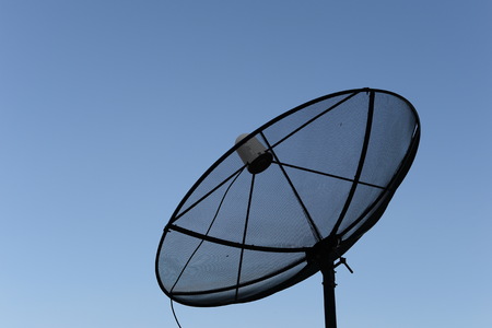 black satellite dish blue sky backgroundの写真素材