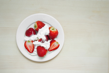red strawberry with white cream on wood backgroundの写真素材