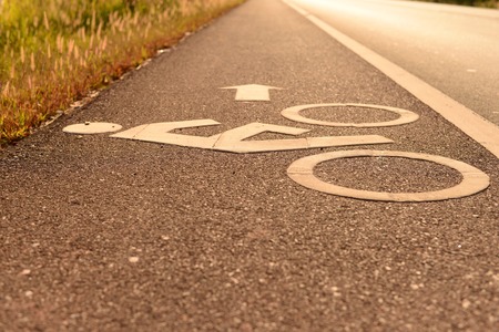 white bicycle lane sign on the roadの写真素材