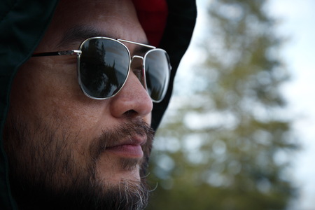 man under hood with sunglassess outdoorの写真素材