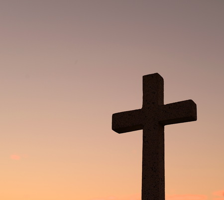 christ cross silhouette on sunset sky backgroundの写真素材