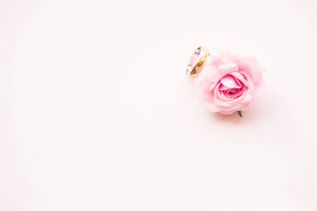 pink rose with weddind diamond gold ring on white backgroundの写真素材