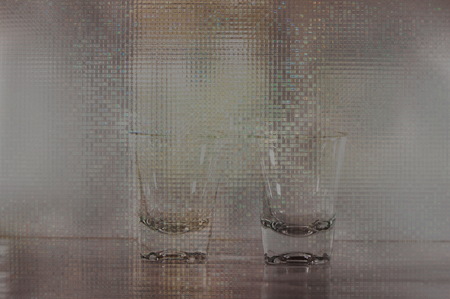 two shot clear party glasses on silver glitter backgroundの写真素材