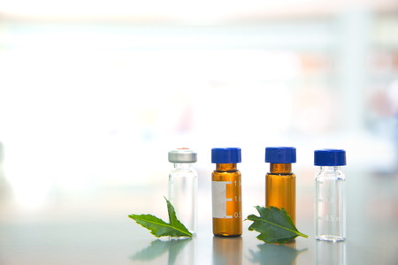 glass vial with green leave in science laboratory on  white lightの写真素材