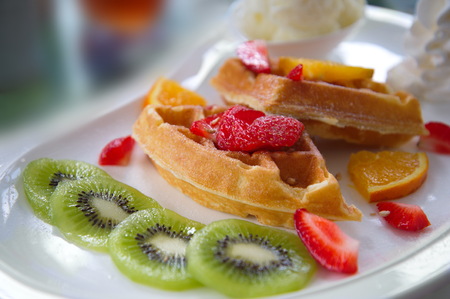 fruit waffle kiwi strawberry orange  dessert on white dishの写真素材