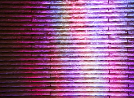 rainbow color glow on the brick wall background at nighrt