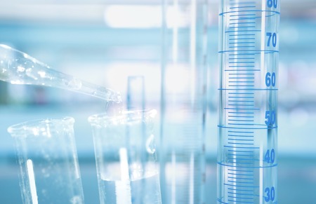 cylinder with scale and test tube water drop with science laboratory blue background