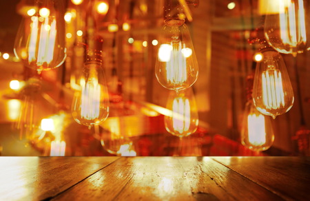 top of wood table with party lamp in bar or pub background
