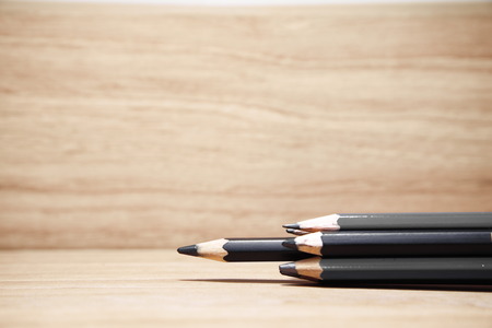 group of black color sharp pencils for writing on wood background one of out standing or leader business conceptの写真素材