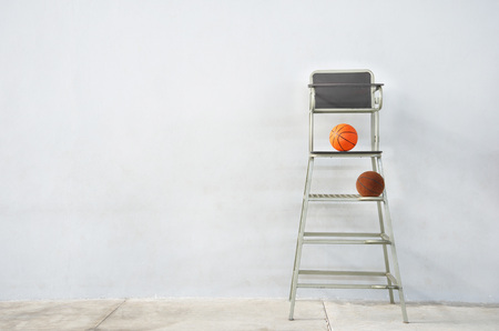 high referee or judge sport chair for indoor math with orange basketball with white cement wall backgroundの写真素材