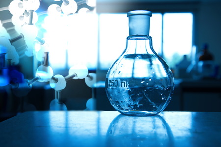 glass round flask in blue medical science technology laboratory backgroundの写真素材