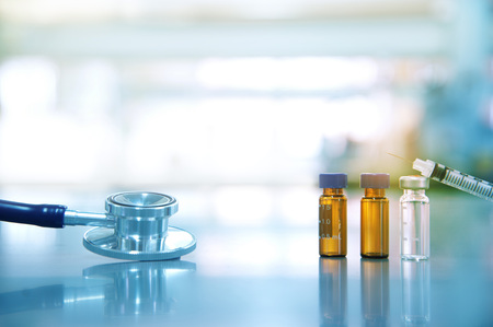 stethoscope for doctor analysis with drug vial and syringe in science laboratory backgroundの写真素材