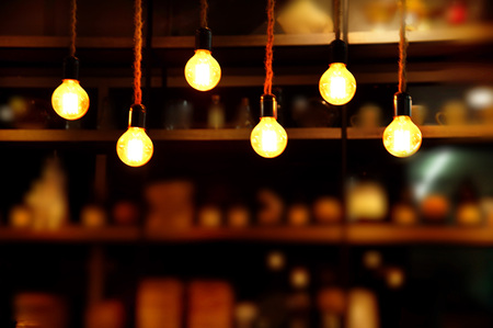 decor hanging yellow orange light lamp with blur party bar or pub dark night backgroundの写真素材