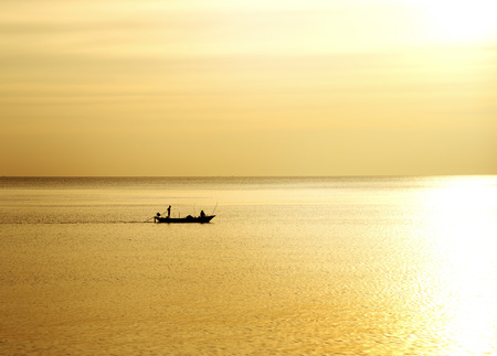 black silhouette fishing boat with light nature golden sunset on the summer clam sea background