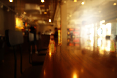 blur wood table in bar or pub at night with lamp light from window background