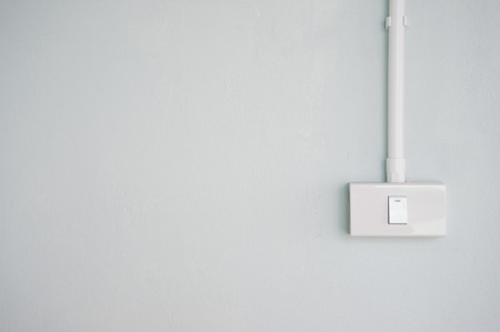 white electric turn on switch on pale pastel green gray blue concrete background interior room