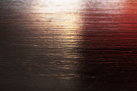 black wood with red light rough textured surface backgroundの写真素材