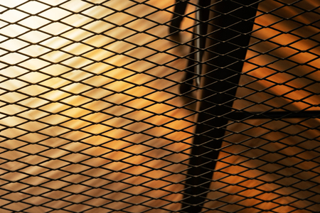 black loft metal net architecture decoration of the room with orange sunlight backgroundの写真素材