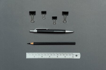 classic black pen pencil paper clip and silver ruler office supply on grey paper for business ans...