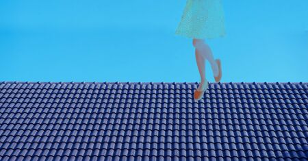 woman in polka dot dress standing on the dark blue ceramic roof top in creative freedom working oncept backgroundの写真素材
