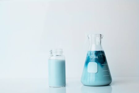 green creamy milky glass  flask and vial in food science laboratory background