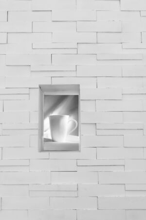ceramic coffee cup on the window of white brick wall interior modern minimalism design backgroundの写真素材