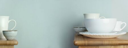 white ceramic coffee and tea mug or cup and dish set for food and drink on wood table with home interior vintage blue web banner backgroundの写真素材