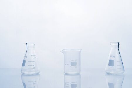clear glass beaker and flask in clean white blue research and develoment science laboratory background の写真素材