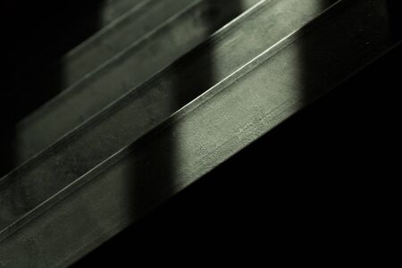abstract textured black metal stair shadow architecture backgroundの写真素材